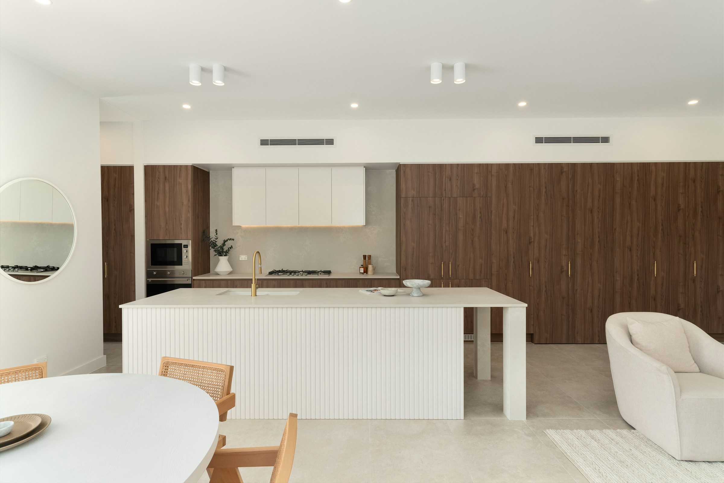 Warm contemporary kitchen with natural wood cabinetry and a sculptural stone island